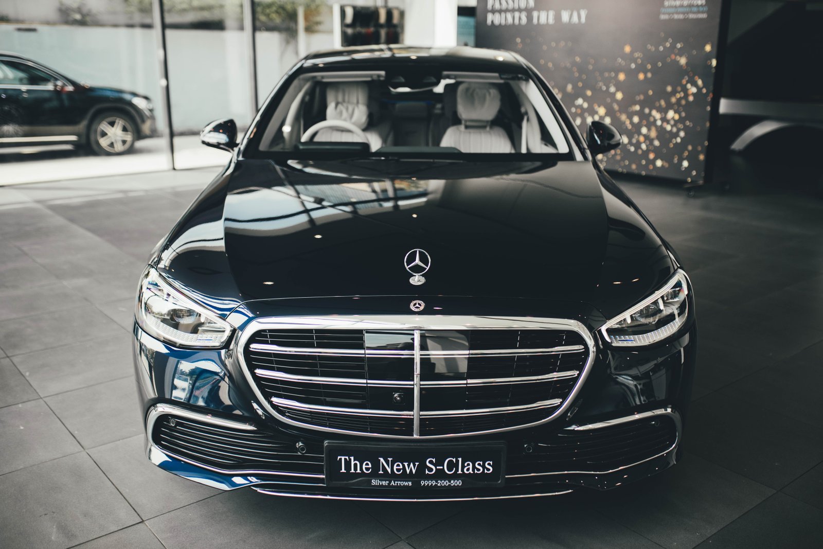Front view of a luxury Mercedes-Benz S-Class on display in a New Delhi showroom.