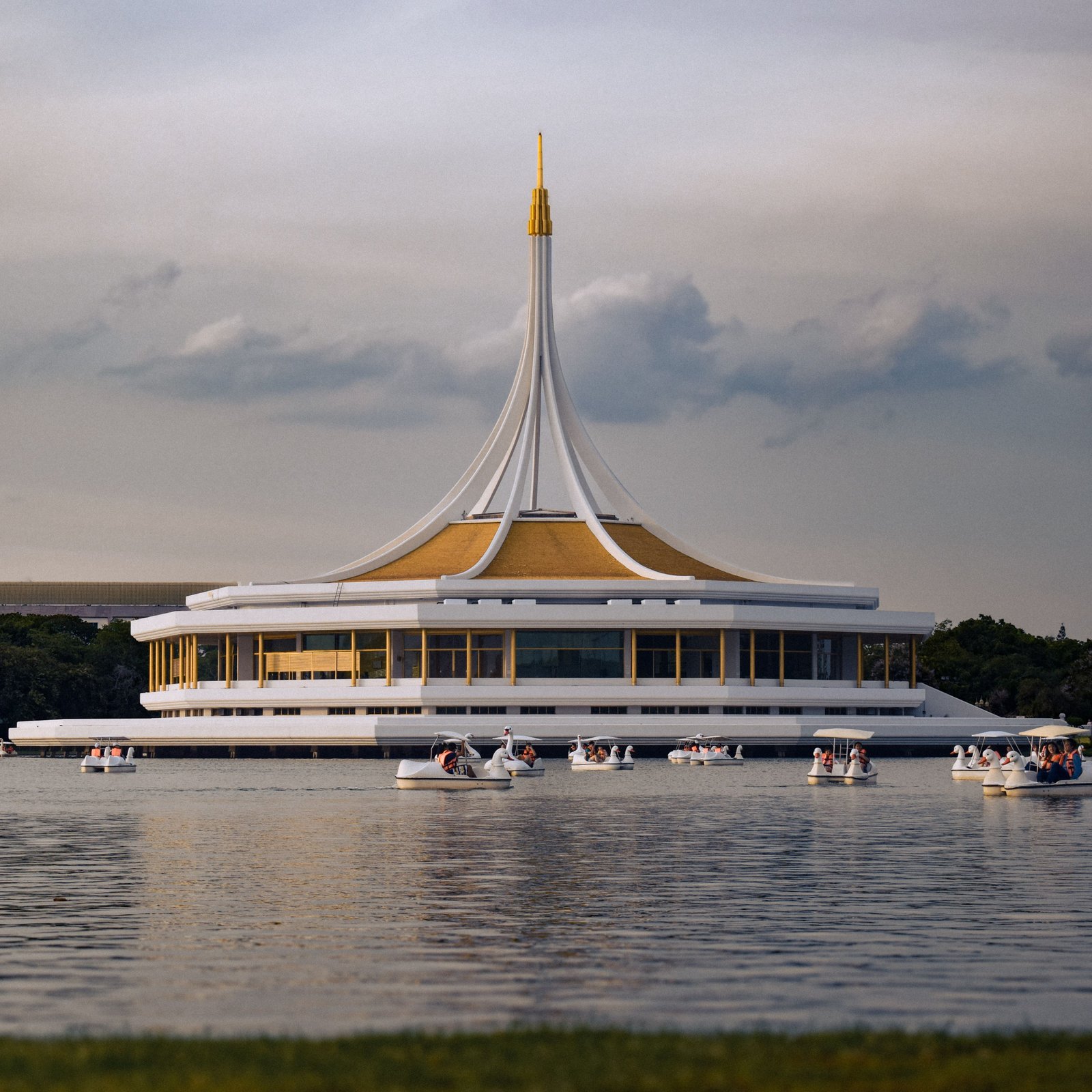 Modern architectural building at Suan Luang Rama IX Park, Bangkok, reflecting on a serene lake.