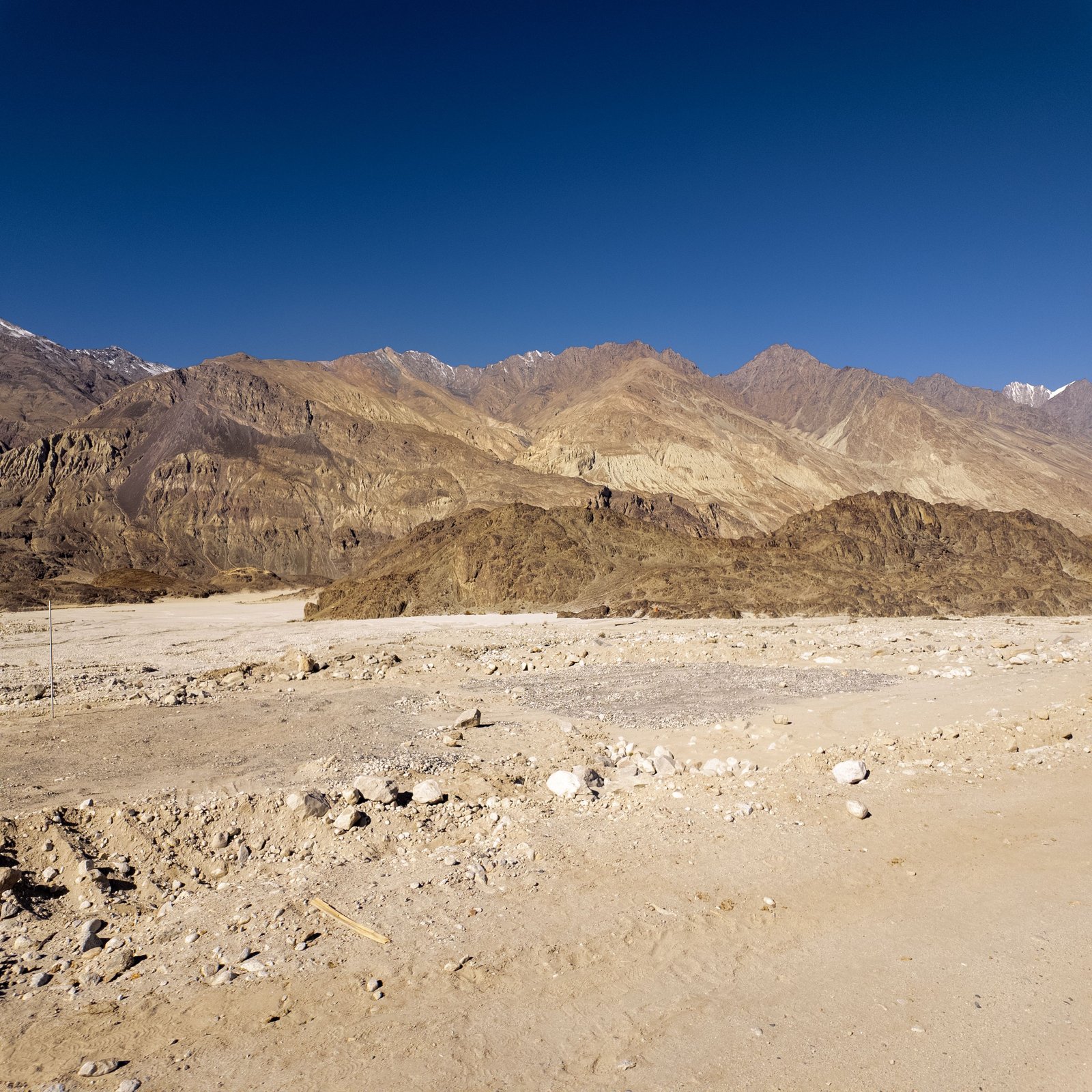 Stunning landscape of barren mountains in Ladakh, India under a clear blue sky.