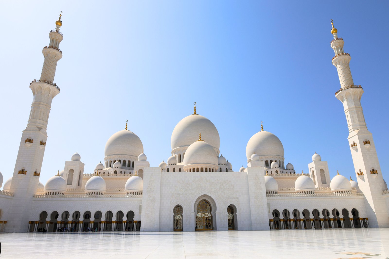 Stunning view of the Sheikh Zayed Grand Mosque in Abu Dhabi with clear blue skies.